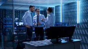 três funcionários discutem em um data center