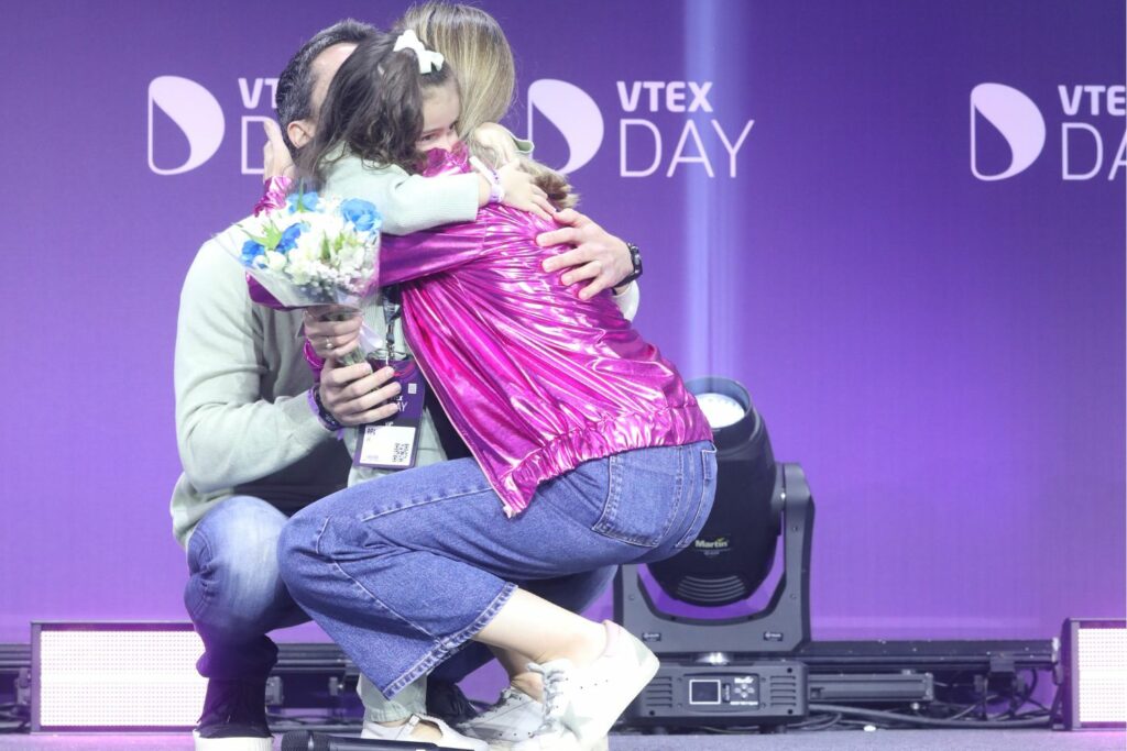 Rafaela Rezende, general manager da VTEX Brasil, recebe sua promoção no VTEX Day, com a presença da família no palco do evento. Foto: Agência Fmalta. Equipe Gustavo Rampini.