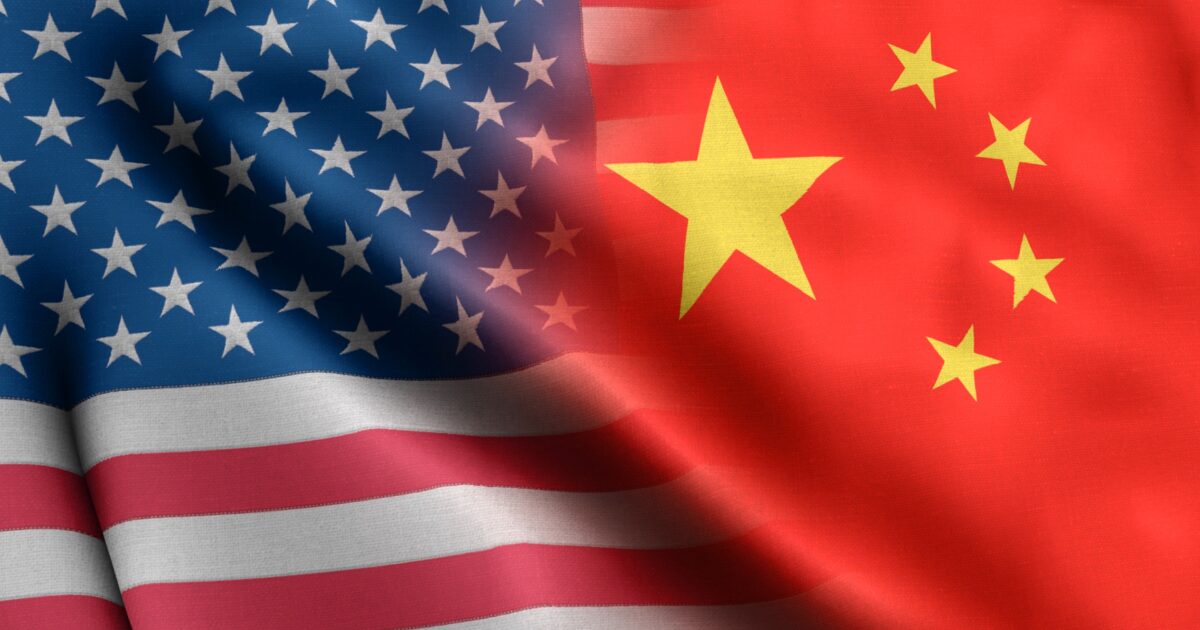 Imagem de sobreposição das bandeiras dos Estados Unidos e da China, destacando os símbolos de ambas as nações. A bandeira americana, com listras e estrelas, se mistura à bandeira chinesa, com fundo vermelho e estrelas amarelas, representando a interação entre os dois países (China, EUA, minerais, tecnologia, tarifa, europa, baidu, software)