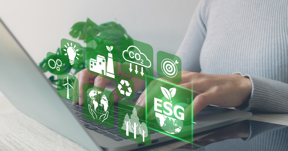 Pessoa usando um laptop com ícones digitais relacionados a ESG (Environmental, Social, and Governance) sobrepostos na imagem. Ícones incluem temas como energia renovável, emissão de CO₂, reciclagem, metas e sustentabilidade ambiental, empresa, stanford