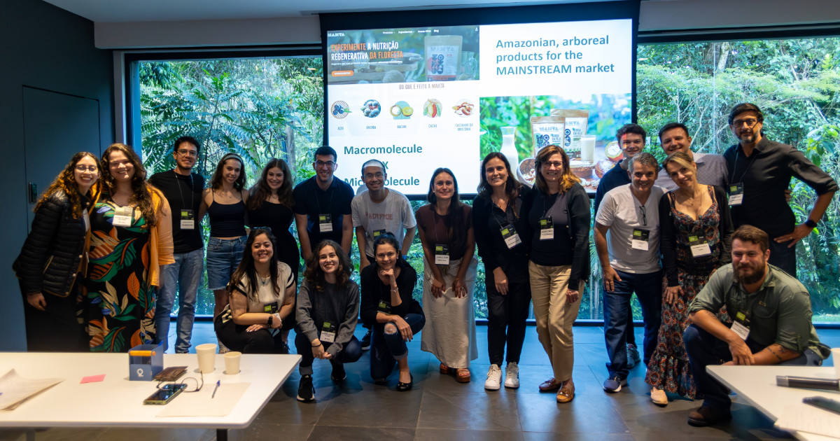 Grupo de alunos da Ivey Business School durante programa de imersão promovido pelo Instituto Itaqui, no Distrito Itaqui, em frente a uma apresentação sobre produtos amazônicos regenerativos para o mercado mainstream