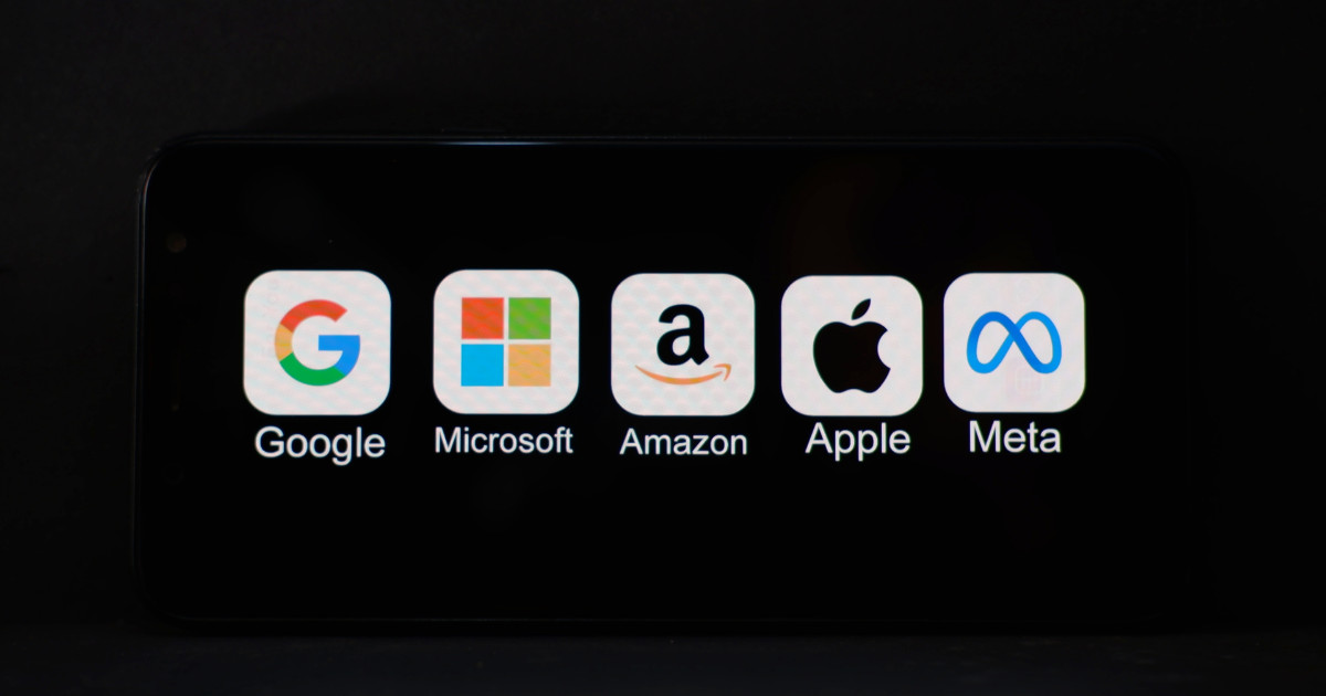 "Imagem mostrando ícones e nomes das principais empresas de tecnologia: Google, Microsoft, Amazon, Apple e Meta, exibidos em uma tela preta. Representação das chamadas 'Big Techs'