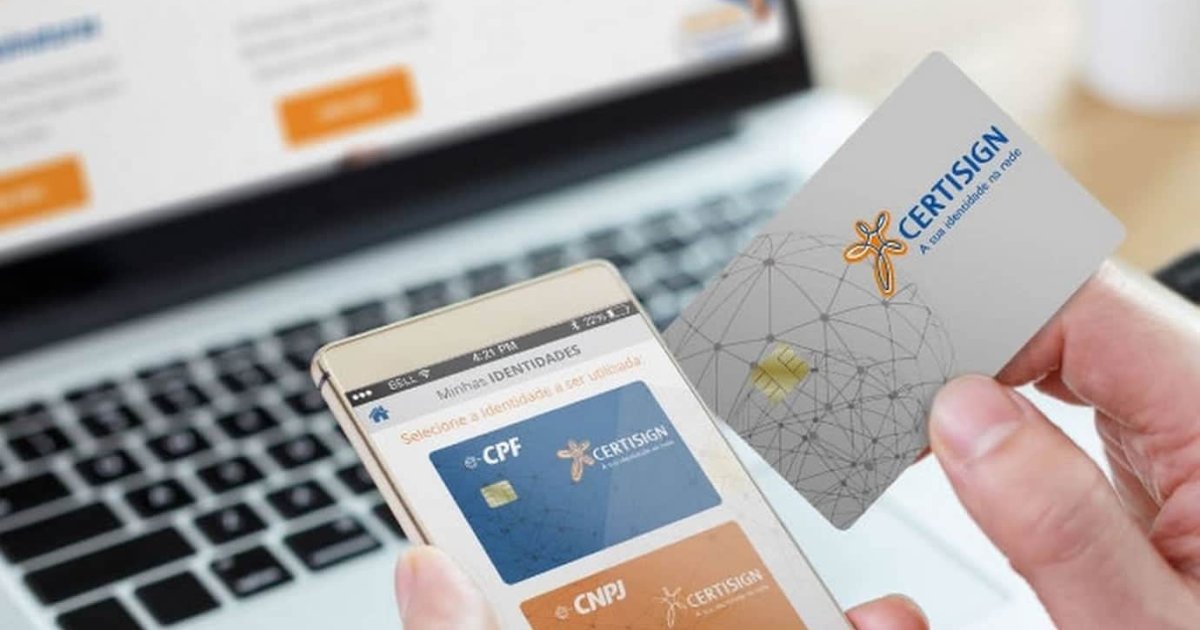Imagem mostrando uma pessoa segurando um cartão de certificação digital da Certisign e um smartphone com um aplicativo aberto, exibindo opções de identidade digital para CPF e CNPJ. Ao fundo, há um notebook com uma tela desfocada