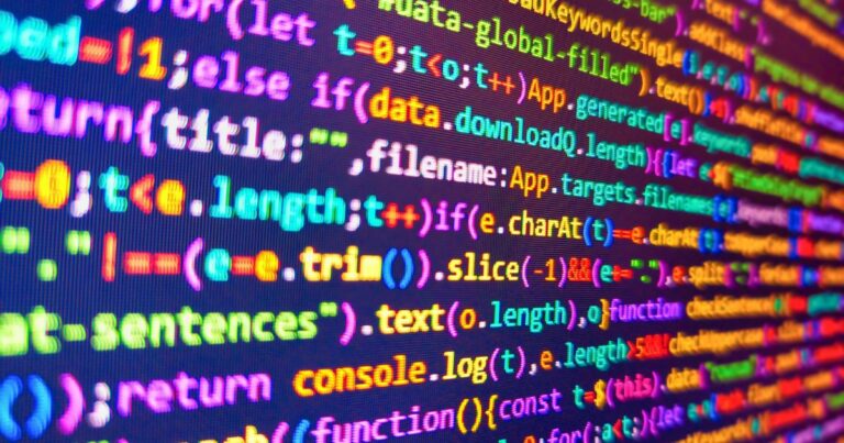 ela de computador exibindo linhas de código coloridas, provavelmente escritas em JavaScript ou linguagem semelhante. O código contém elementos como funções, variáveis e métodos, com destaque em cores diferentes para palavras-chave, strings, números e outros componentes da sintaxe. Trecho visível do código inclui estruturas como if, function, console.log e manipulação de strings, vibe (V8.Tech)