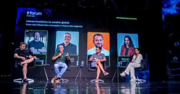 Imagem de um painel no evento IT Forum Trancoso 2025 com o tema “Líderes brasileiros no cenário global: Como eles influenciam a inovação e o futuro dos negócios”. Sentados no palco estão cinco pessoas participando da discussão. Entre os painelistas estão Cesar Gon, fundador e CEO da CI&T; Marco Stefanini, fundador e CEO global da Stefanini; e Rodrigo Caserta, CEO global da Avanade. Atrás dos participantes, há um telão exibindo os nomes e fotos dos palestrantes com a identidade visual do evento.