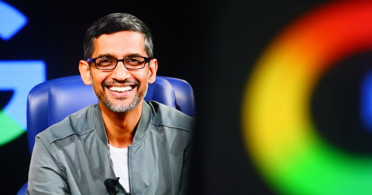 A imagem mostra uma pessoa sentada em uma cadeira azul, em um ambiente que parece ser um palco ou estúdio de apresentação. À direita, há um grande logotipo colorido do Google, parcialmente visível, com as cores características (verde, vermelho, amarelo e azul).