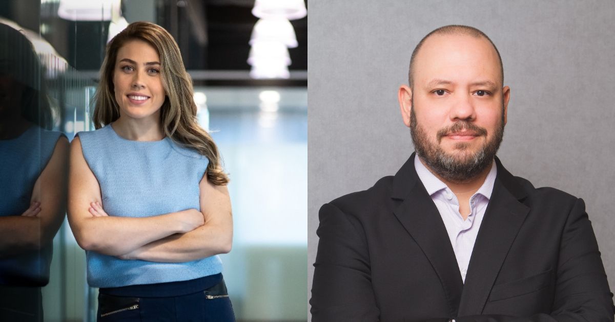 A imagem é composta por duas partes lado a lado: À esquerda: Uma pessoa está posicionada próxima a uma parede de vidro, com os braços cruzados. Veste uma blusa sem mangas em tom azul claro e calça escura. O fundo mostra um ambiente corporativo moderno, com iluminação suave e elementos arquitetônicos como luminárias pendentes. À direita: Outra pessoa aparece com os braços cruzados, vestindo um terno preto com camisa social clara. O fundo é neutro, em tom cinza, sugerindo um cenário formal, típico de retratos corporativos. (WhatsApp)